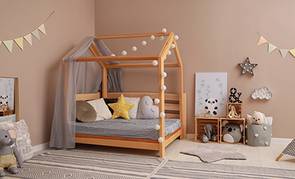 Una cama estilo casita montessori destaca en un dormitorio infantil.
