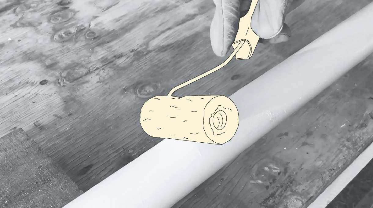 una persona pinta el mástil para bandera con pintura y un rodillo.