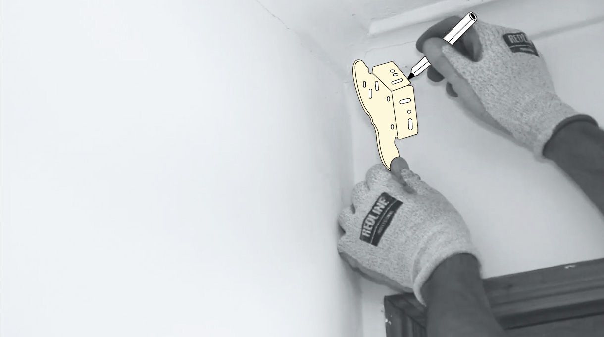 una persona hace los agujeros para instalar la base de la cortina