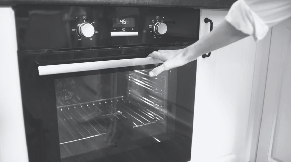 mano apoyada en puerta de horno
