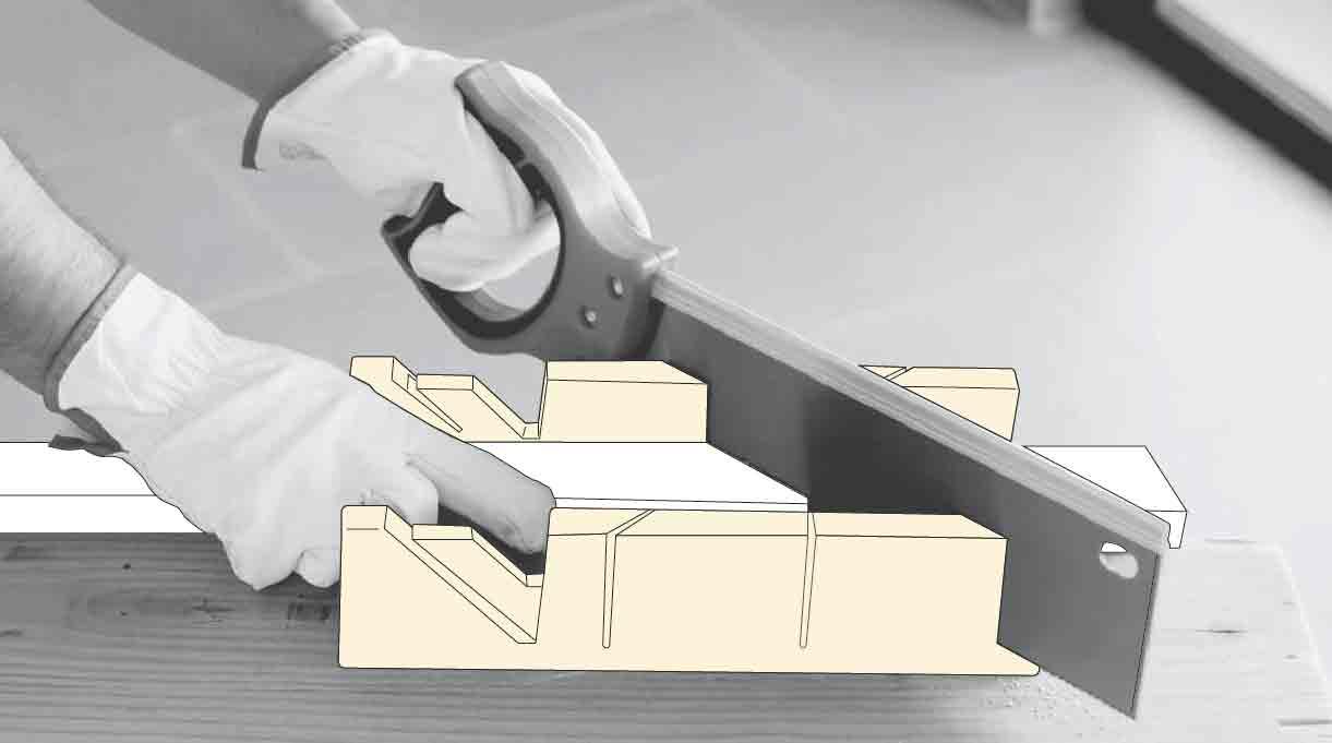 manos con serrucho cortando listón con la caja de ingletes