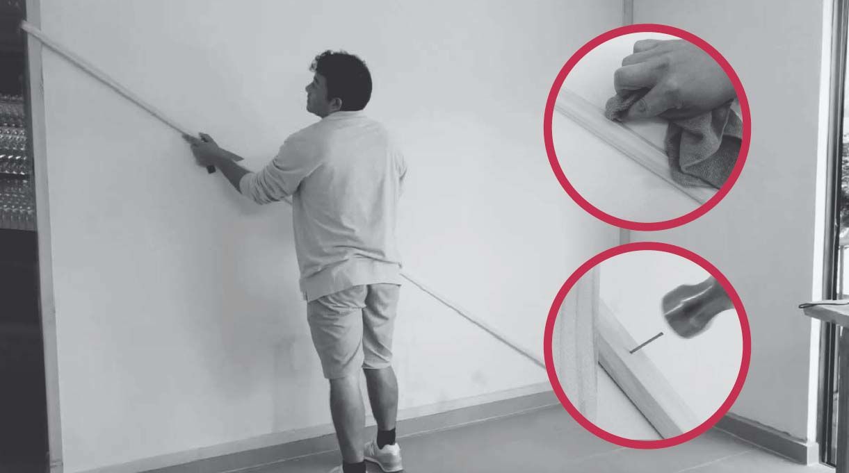 hombre pegando la primera moldura en el muro