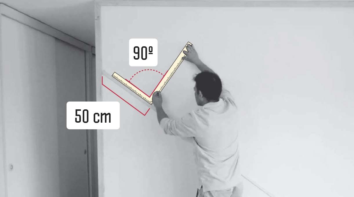 hombre midiendo para instalar la segunda moldura en el muro