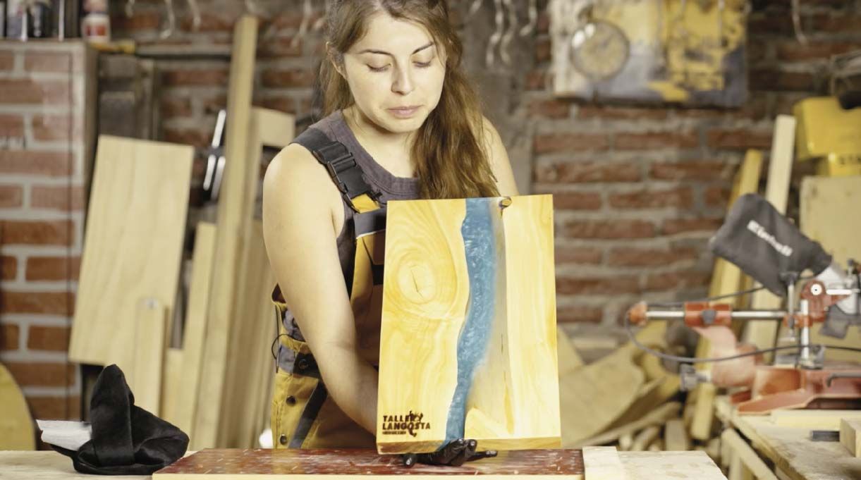 Mujer mostrando la tabla de picar con resina terminada