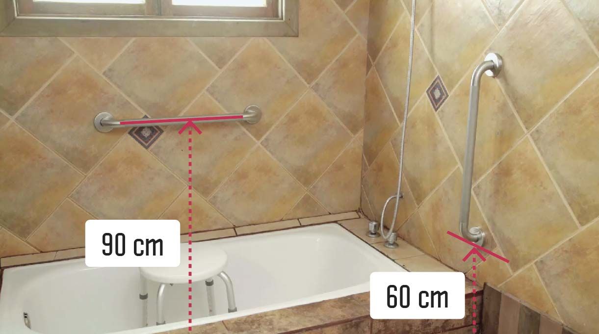 Tina y ducha con barra horizontal de apoyo, que debe ir a una altura de 90 cm, y barra de forma vertical a la entrada de la ducha, que debe estar a 60 cm del piso.