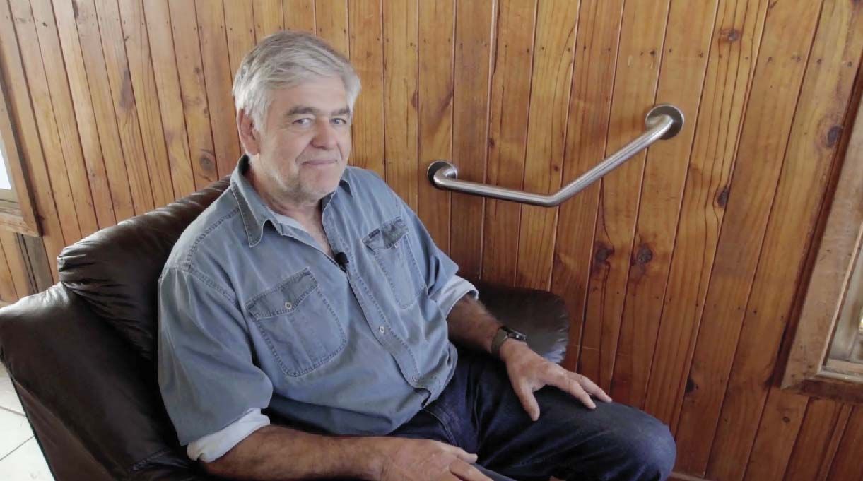 Alejandro Tardel sentado en un sillón y en la pared un barra de seguridad angular