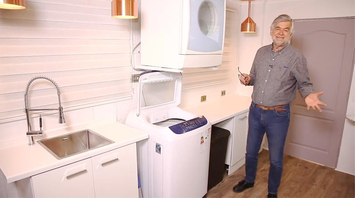 Tardel junto a la lavadora que tiene su tapa abierta