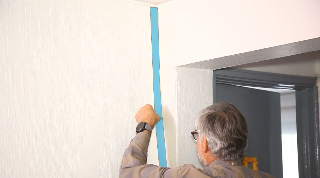 Alejandro Tardel colocando cinta de enmascarar antes de pintar