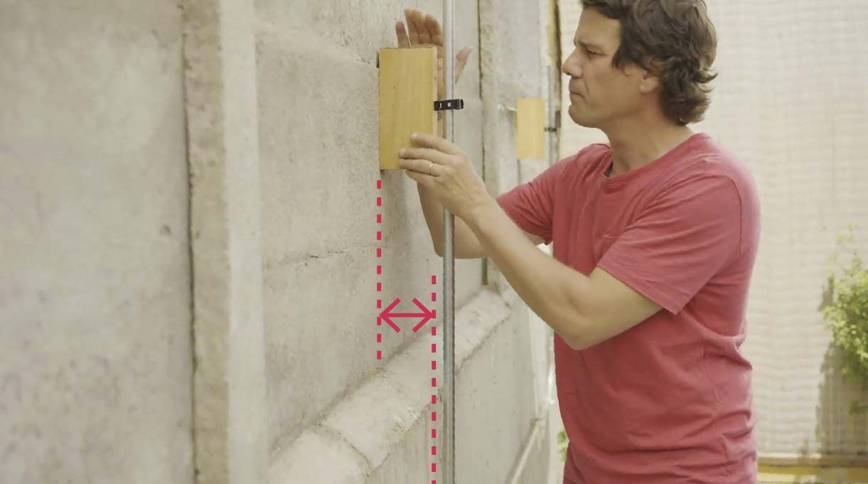 Roberto Droste colocando tacos de madera en el muro
