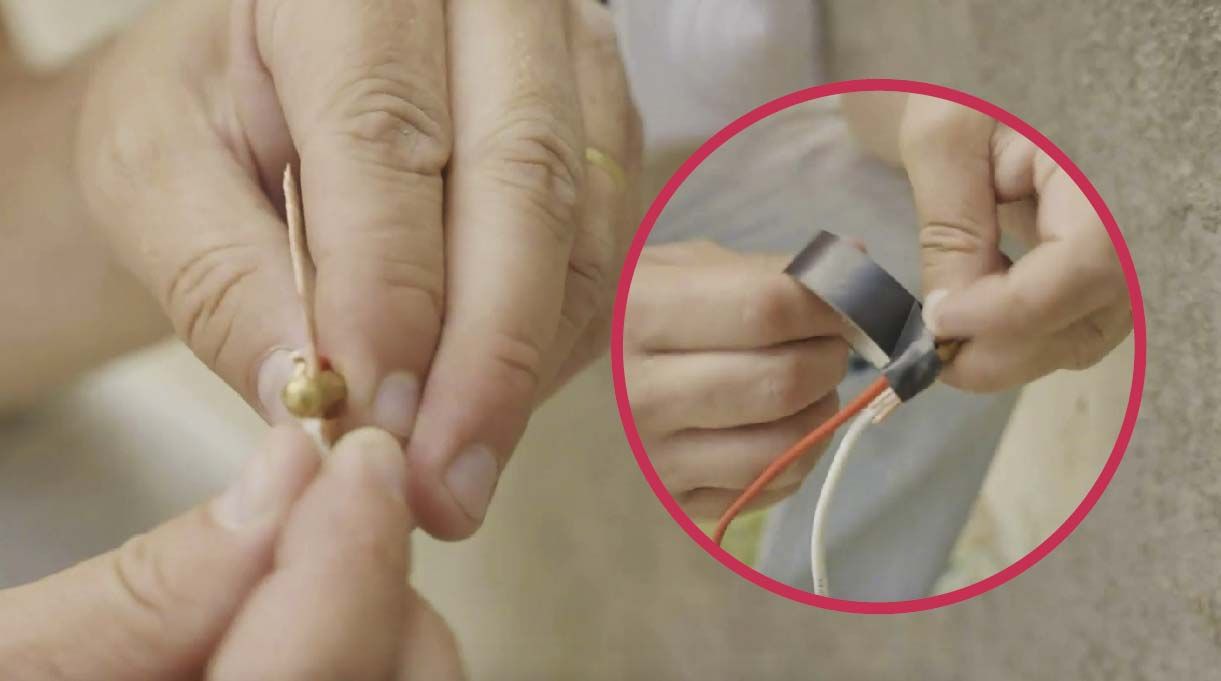 manos amarrando el inicio del pasador con los cables con cinta adhesiva eléctrica