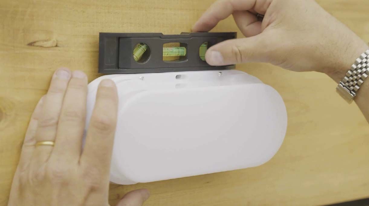 Droste chequeando si el foco quedó derecho instalado usando un nivel burbuja