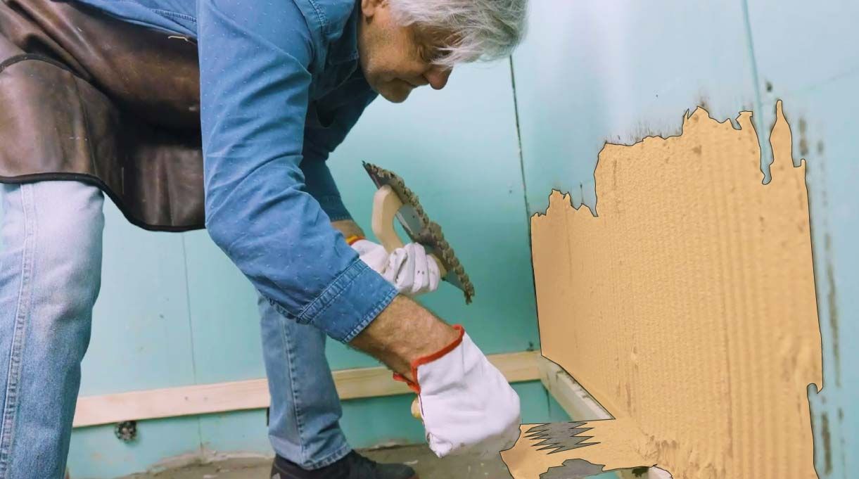 Alejandro Tardel pone el adhesivo con una llana dentada encima de la línea maestra.