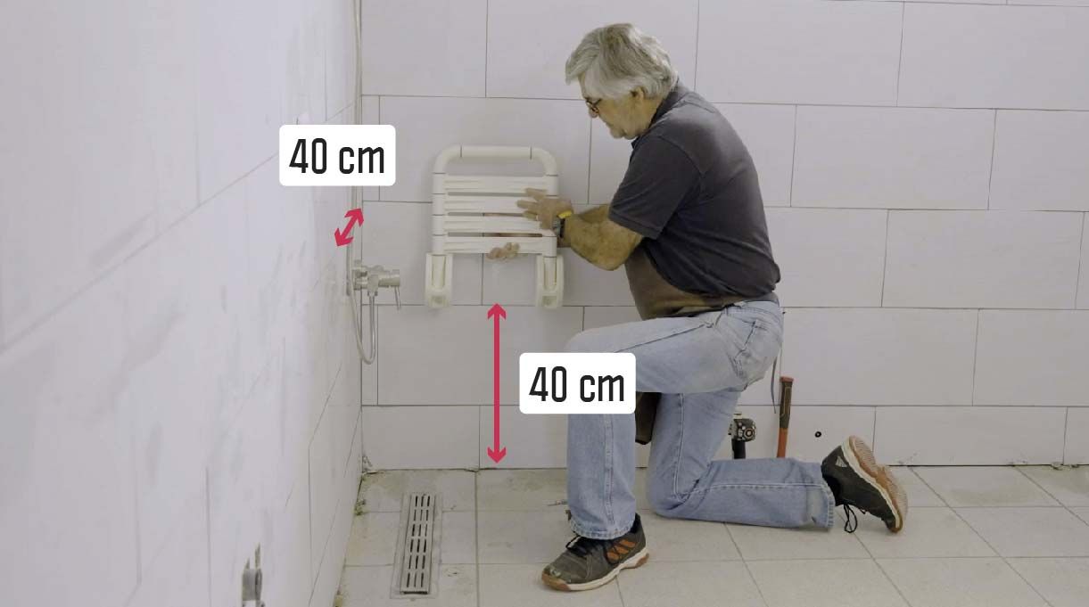 Alejandro Tardel poniendo una silla abatible. Esta debe quedar La silla debe quedar a 40 cm de la pared de la ducha y a 40 cm de altura.