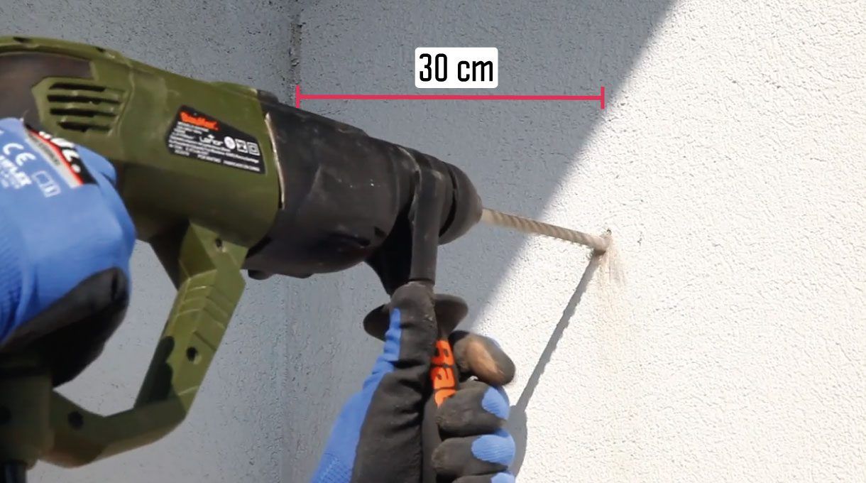 Taladro haciendo un agujero a 30 cm del muro