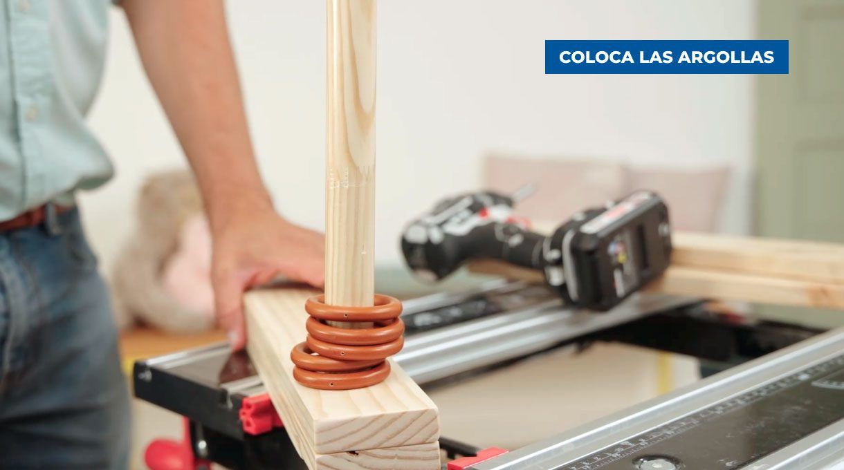Colocación de argollas en la barra de madera.