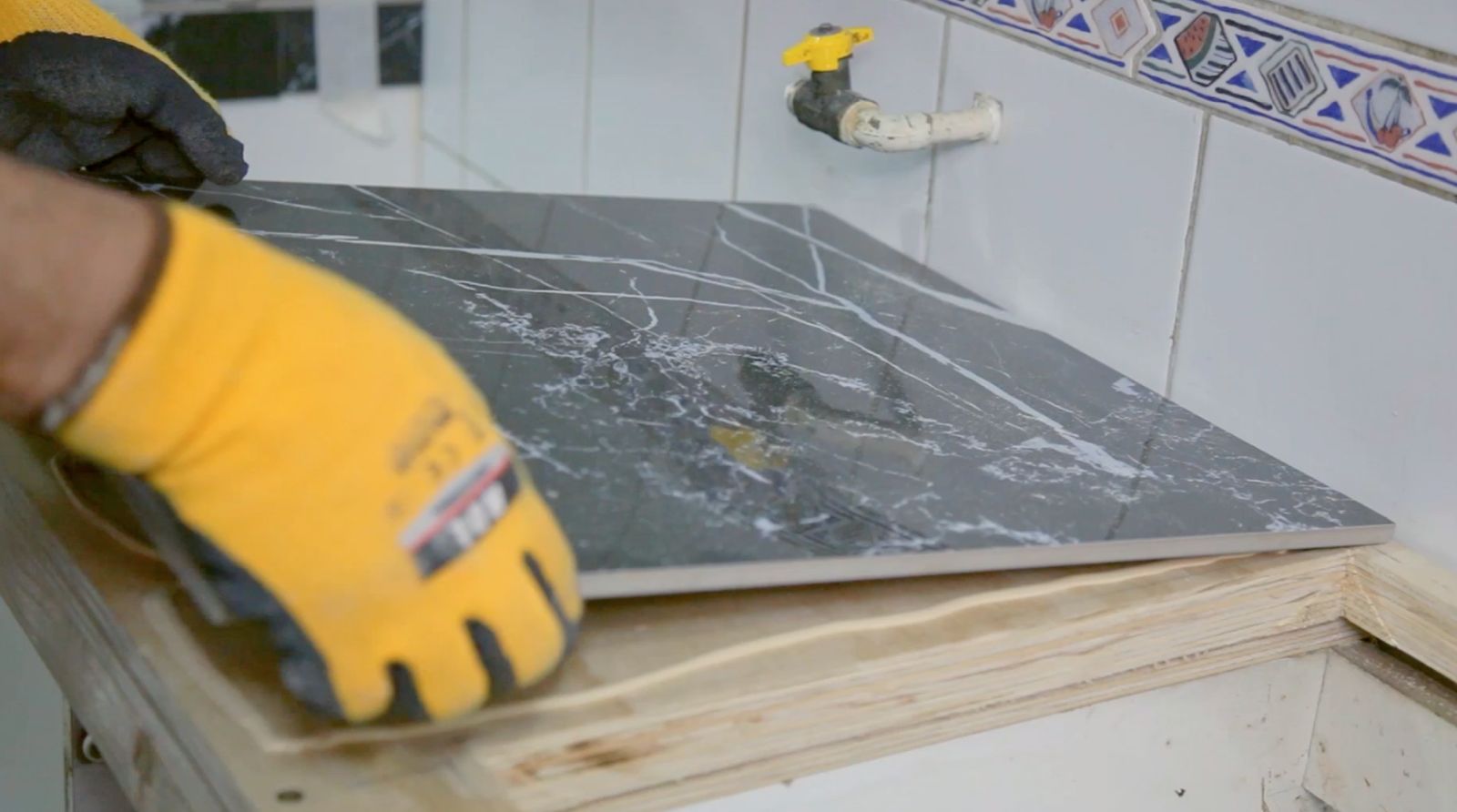 Pegado de la cubierta de porcelanato en mueble para lavaplatos