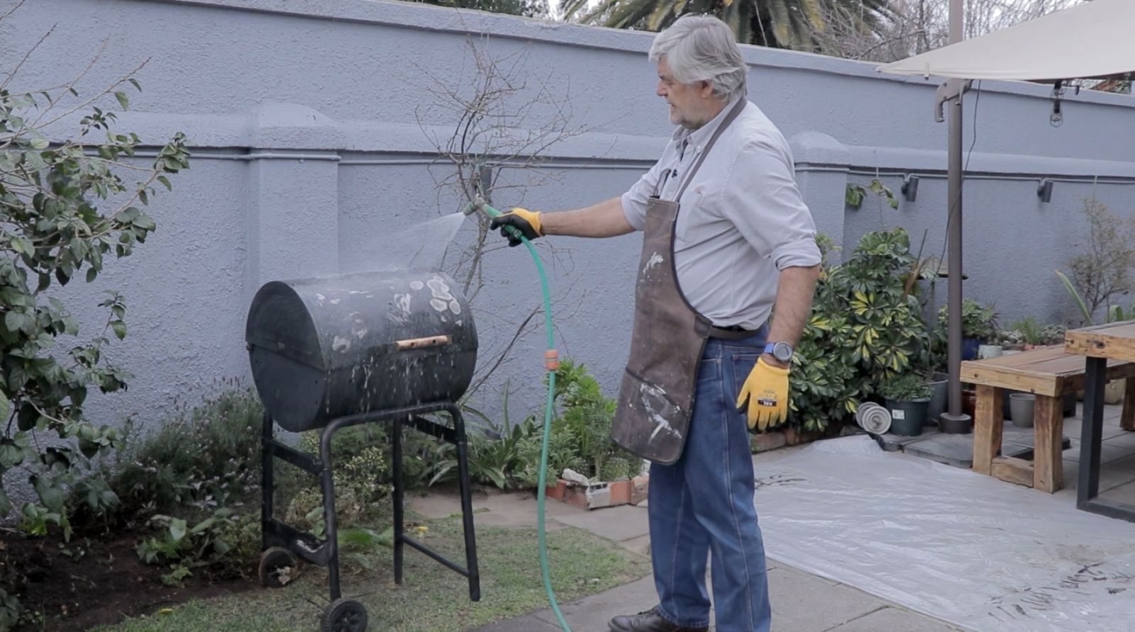 Limpieza con agua y manguera de la parrilla a carbón