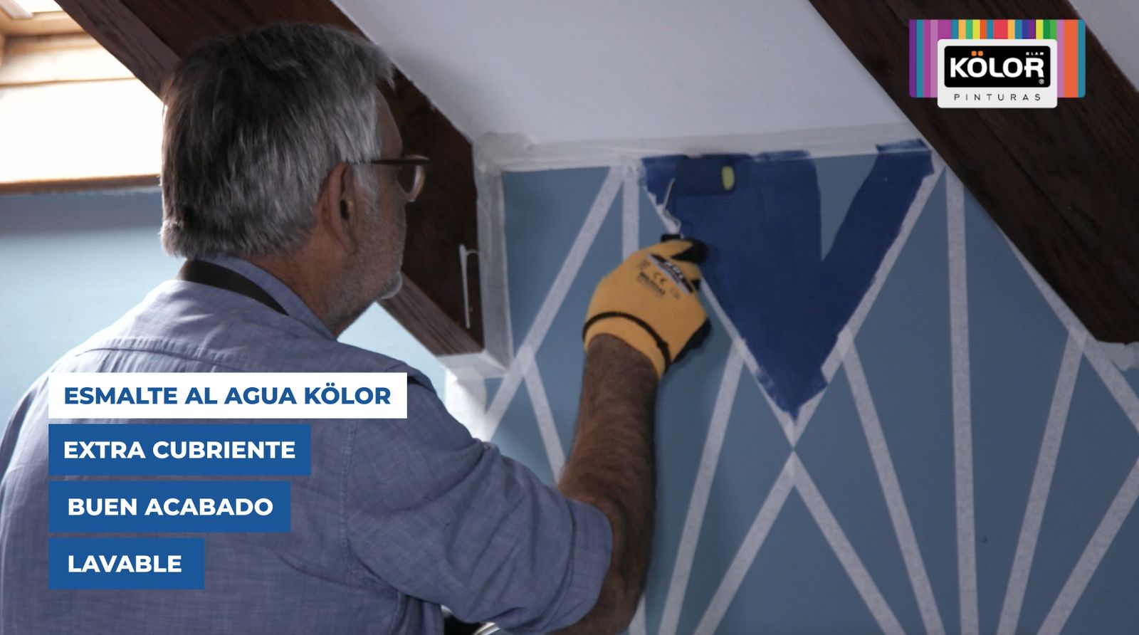 Una persona pinta parte del mural con esmalte al agua Kölor y un rodillo de esponja