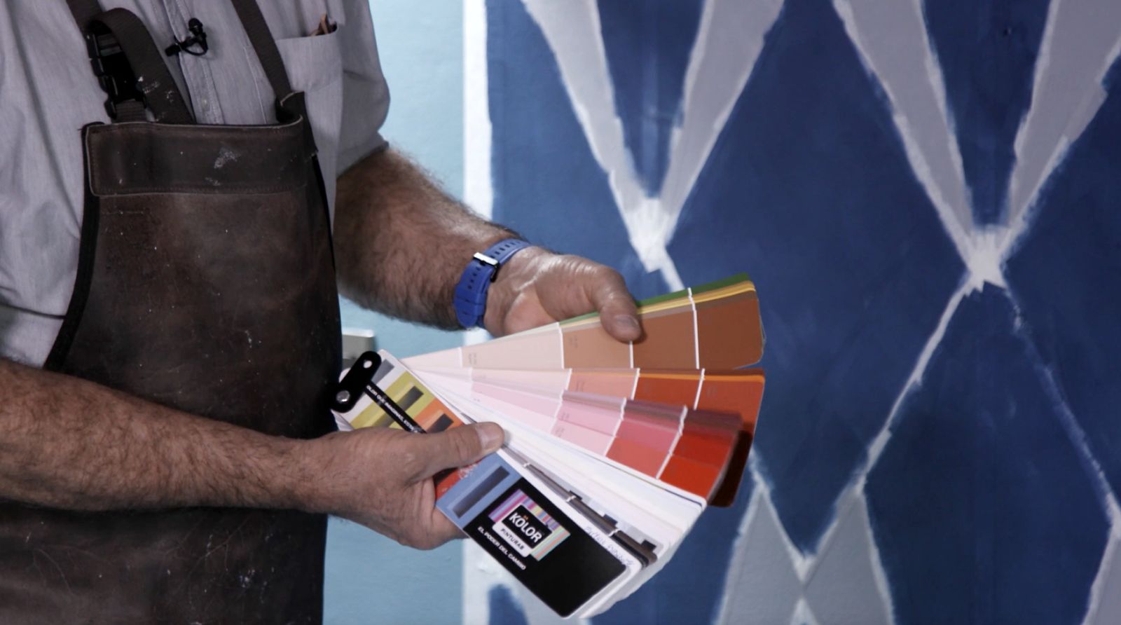 Una persona mostrando un muestrario de la paleta de color de la marca Kölor
