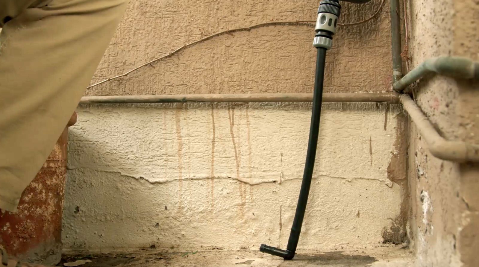 Se ve la unión rápida para manguera unida a la tubería que luego se une a un codo y llega hasta el piso