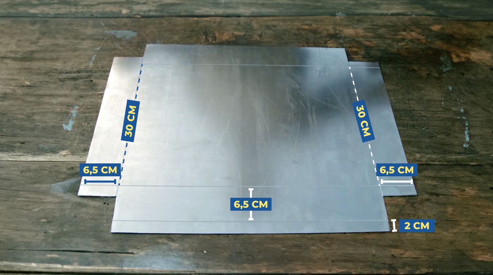 Se ve la plancha metálica para armar la parrilla plegable con sus esquinas cortadas