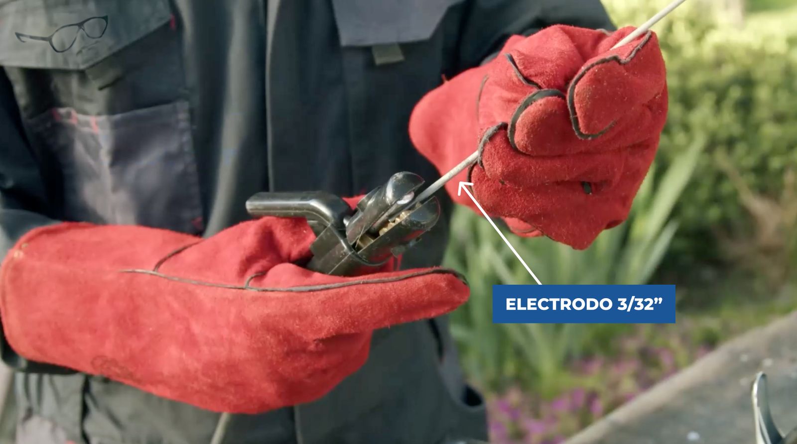 Se ve una persona con guantes de cuero y una pinza con electrodo para soldar
