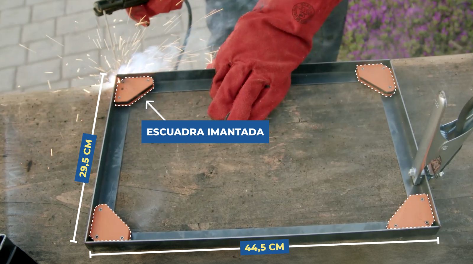 Se ve una persona soldando el marco de la parrilla plegable usando escuadras imantadas en las esquinas