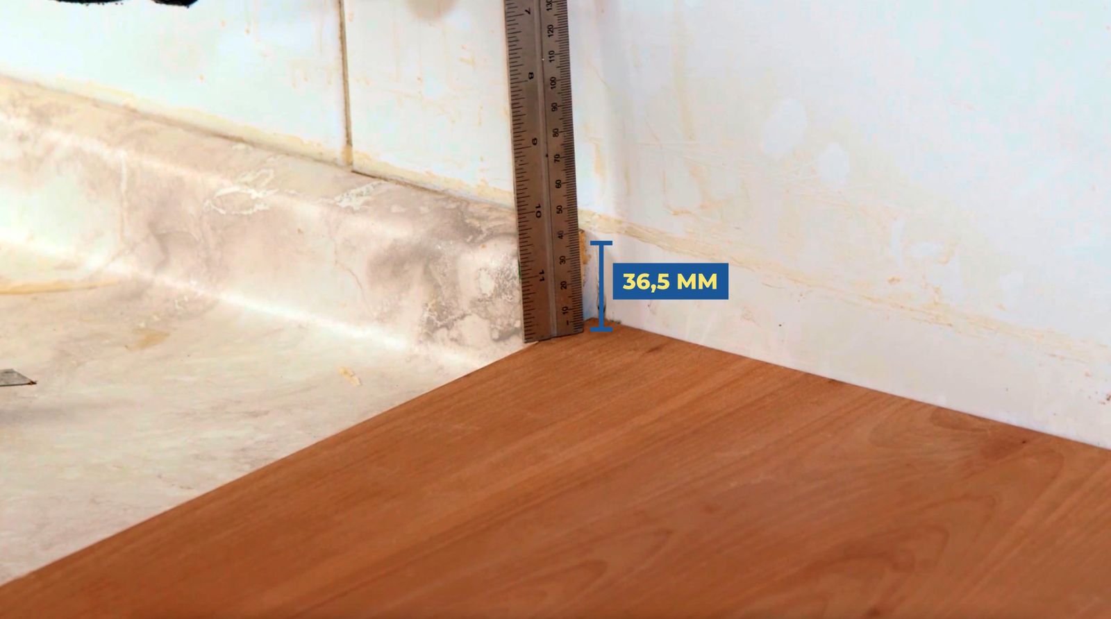 Se ve la altura de 36,5 mm que hay desde la tabla y el final de la melamina en el muro