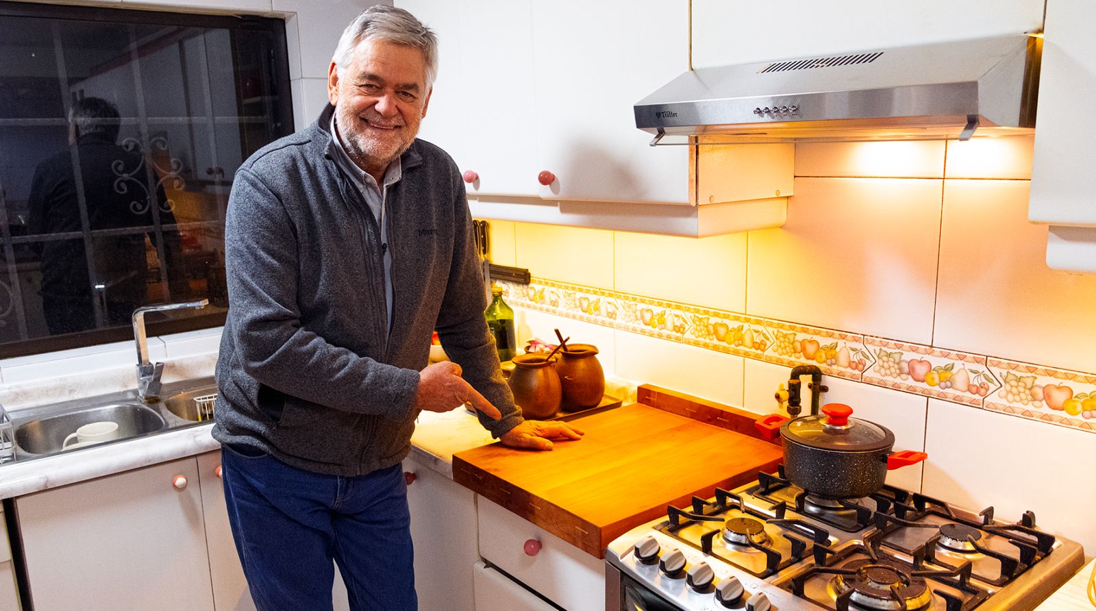 Se ve a una persona mostrando la tabla de madera para cortar terminada, solución para reparar un mesón de melamina.