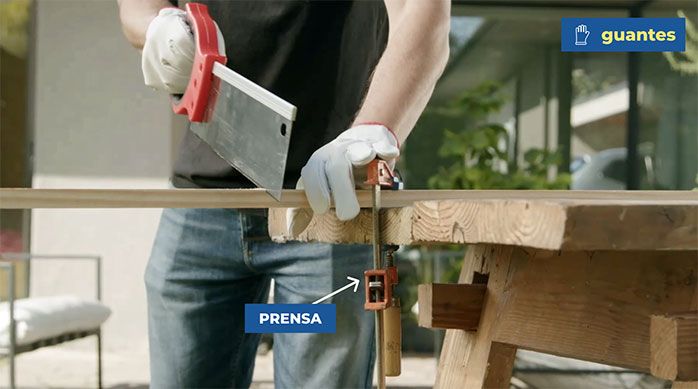 Una persona corta con serrucho costilla el pino seco cepillado para hacer el pino de Navidad