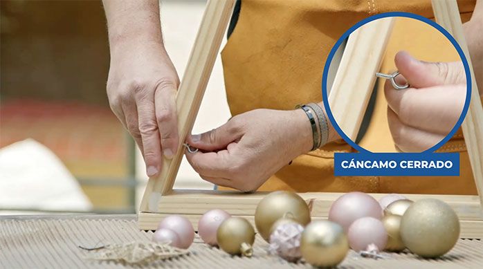Una persona pone cáncamos cerrados por el interior del pino de Navidad