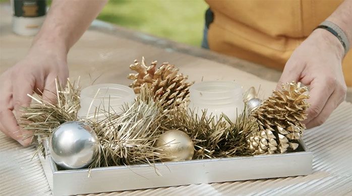 Una persona arma el centro de mesa de Navidad con la decoración navideña renovada