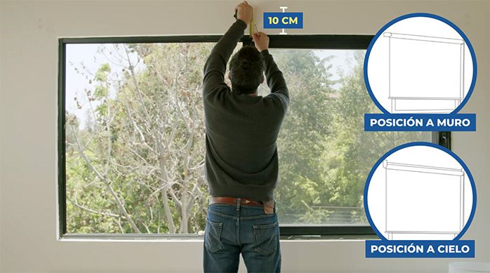 Una persona mide 10 cm sobre el marco superior de la ventana para poner la cortina enrollable o roller