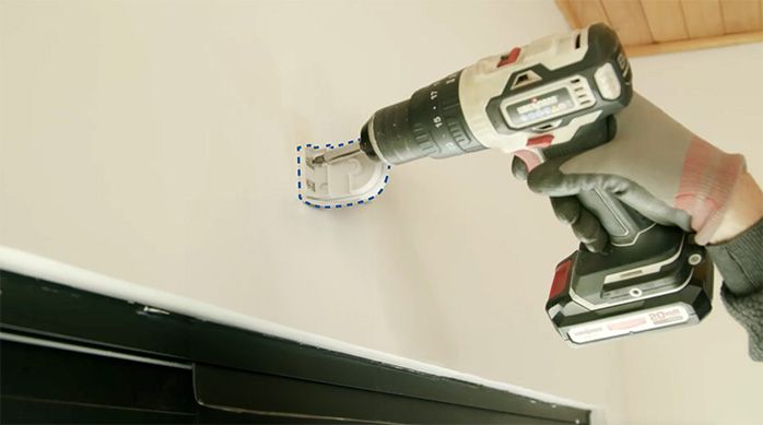 Una persona atornilla los soportes para instalar una cortina roller