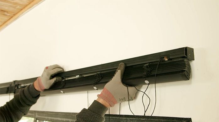 Una persona monta la persiana de pvc sobre los soportes