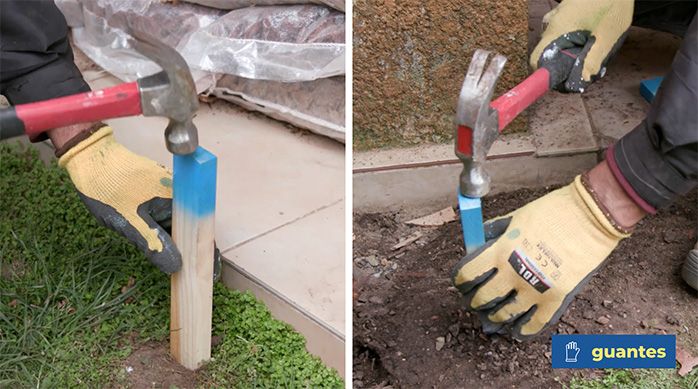 Una persona pone un estaca de madera con un martillo para delimitar el lugar del jardín de piedras