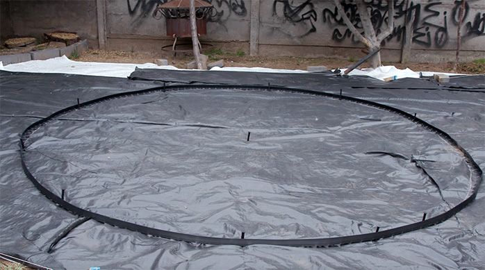 Círculo hecho con el borde plástico para contener las piedras del jardín de piedras