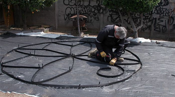 Una persona forma una flor con el borde plástico para jardín