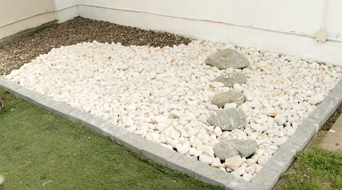 Se ve el piso del jardín japonés en casa cubierto por piedra ágata, cuarzo y bolones