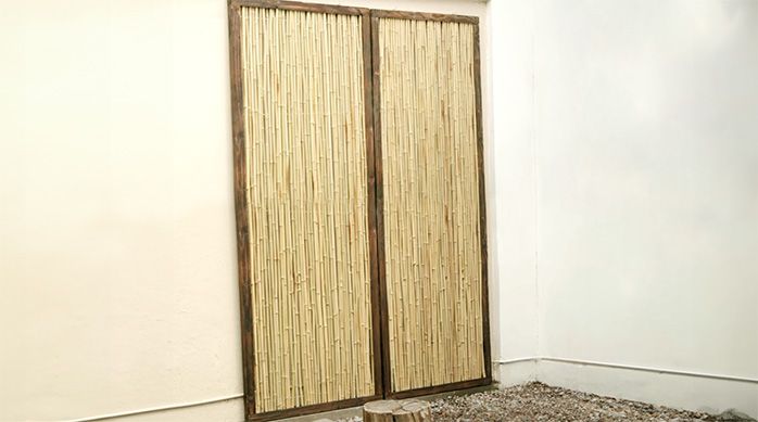 Se ven los paneles de bambú instalados en el muro del patio donde está el jardín japonés