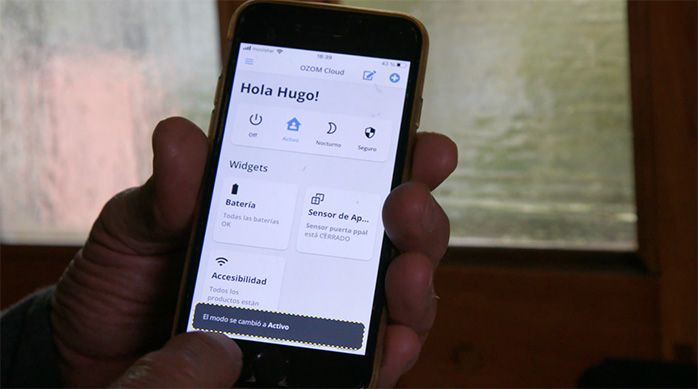 Una persona muestra en el celular los modos que tiene de uso el sensor de puerta