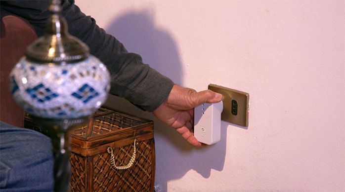 Una persona inserta el enchufe smart en la toma de corriente