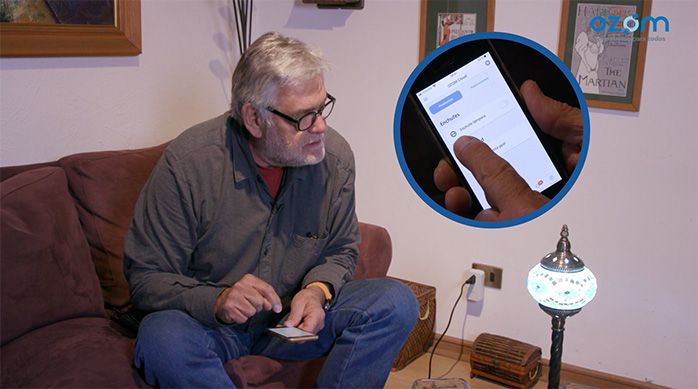Una persona prueba la lámpara enchufada al enchufe smart, controlando desde el celular