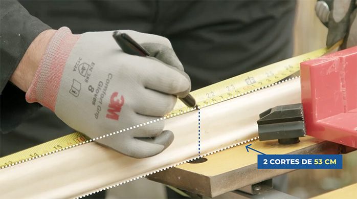Una persona marca 2 cortes de madera para renovar un espejo