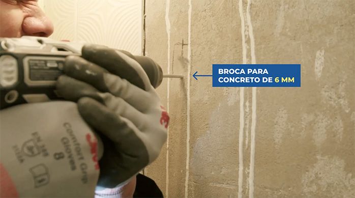 Una persona perfora el muro del baño moderno con una broca para concreto de 6 mm