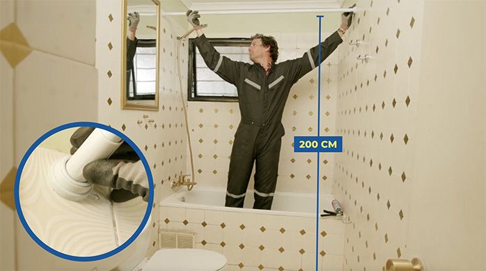 Una persona instala una barra extensible para cortina de baño