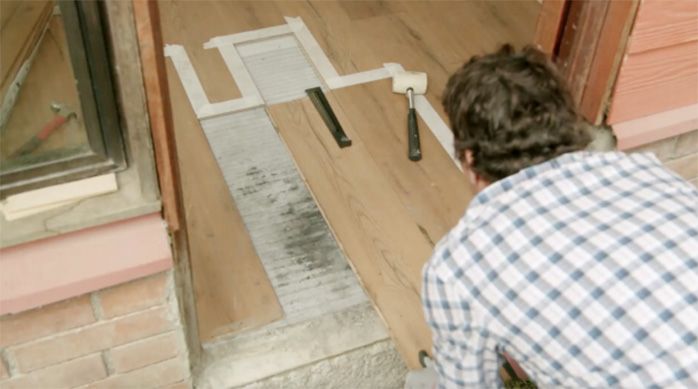 Una persona retira una tabla de piso laminado