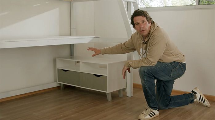 Una persona muestra el mueble bajo con las patas nuevas