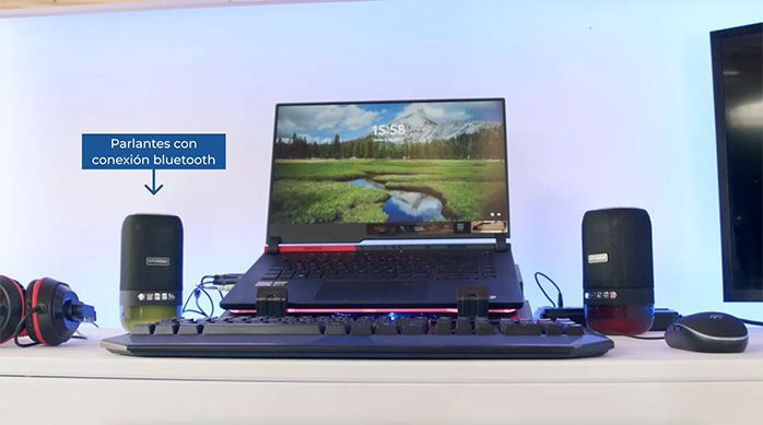 Se ve un notebook con ventilador, teclado, mouse, audífonos y parlantes con conexión bluetooth