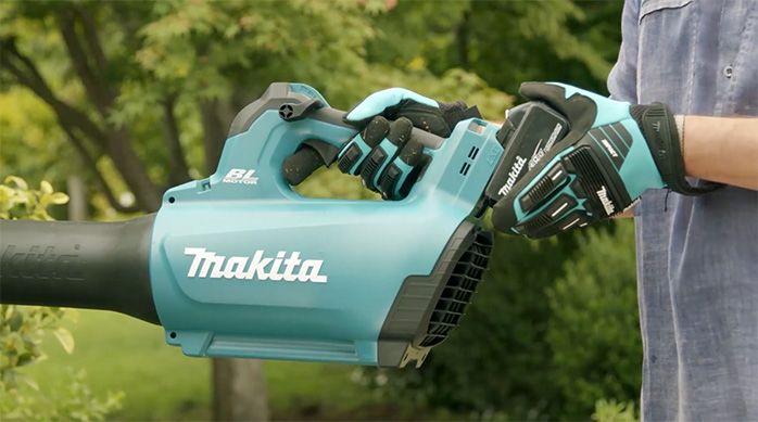 Una persona instala la batería en la sopladora Makita